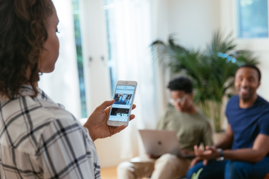 Woman looking at her cell phone with the vivint app.